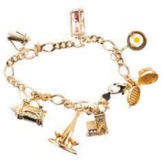 Figaro style 14k yellow gold charm bracelet. Food and drink motif charm bracelet consists of seven charms. A waffle iron, frying pan with egg, sand timer, carafe stein, champagne bottle and glasses and a tavern all in 14k yellow gold. 7.75 inches long. 14k yellow gold Stamped: 14k 24.7 grams Bracelet: 7.75 Inches Cheap Gold Charm Bracelets, Luxury Vintage Charm Bracelet, Luxury Yellow Gold Fine Jewelry Charm Bracelet, Luxury Gold Round Charm Bracelet, Cheap Yellow Charm Bracelet For Gift, Gold Charm Bracelet Gift, Sand Timer, Sand Timers, Jewelry Words