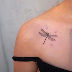 a woman with a dragonfly tattoo on her shoulder