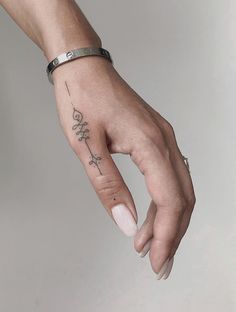 a woman's hand with a tattoo on it and a cross in the middle