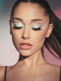 a woman with long hair and blue eyeshadow