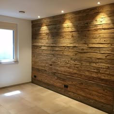 an empty room with wood paneling on the wall and lights in the window sill