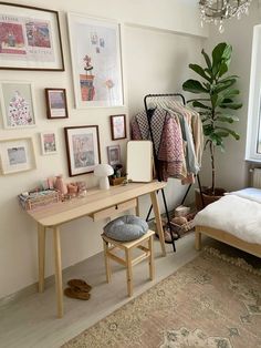 a bedroom with a bed, desk and pictures on the wall