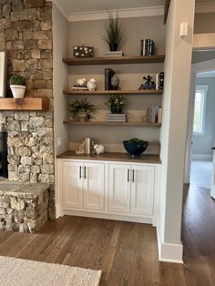 a living room filled with furniture and a fire place in front of a stone fireplace