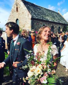 a bride and groom walking through confetti thrown by guests