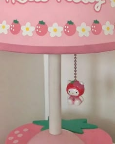 a pink lamp with a hello kitty hanging from it's side