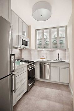 a kitchen with white cabinets and stainless steel appliances