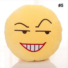 a yellow smiley face pillow sitting on top of a table