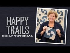 a woman holding up a piece of fabric with the words happy trails quilting on it