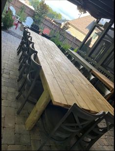 a long wooden table sitting on top of a brick patio