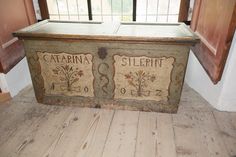 an old wooden box with two signs on it sitting in front of a windowsill