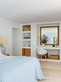 a bedroom with white walls and blue bedding