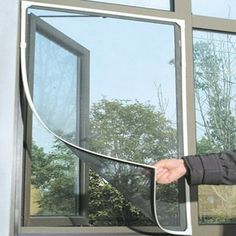 a man is standing outside with his hand on the side of a window that has been partially opened