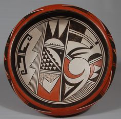 an orange and black bowl with designs on it