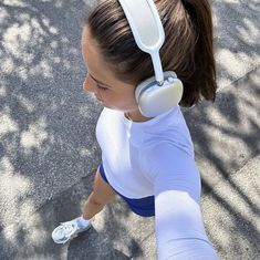 a woman with headphones on walking down the street