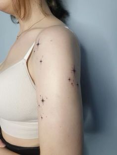 a woman wearing a bra with stars on her left arm and right arm behind her back