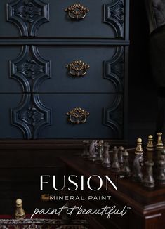 a black dresser with gold handles and knobs next to a chess set on a rug