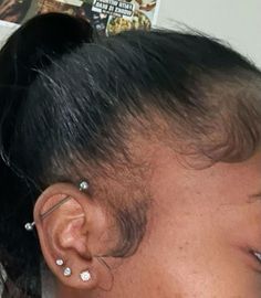 the back of a woman's head with ear piercings