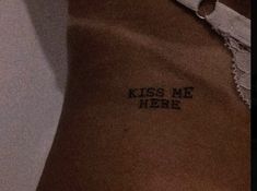 a woman's stomach with the words kiss me here written on it