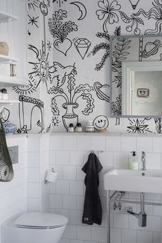 a white toilet sitting under a bathroom mirror next to a wall mounted faucet