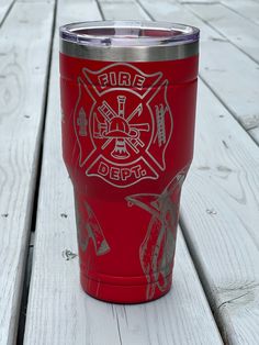 a red fire department cup sitting on top of a wooden table