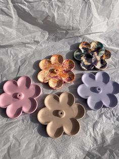 four flower shaped dishes sitting on top of a sheet of paper next to each other