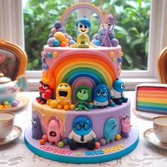 the cake is decorated with cartoon characters and rainbow colored frosting on it's sides