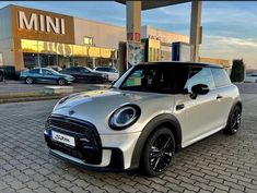 a white mini cooper parked in front of a store