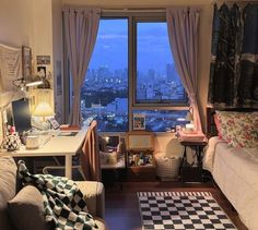 a bedroom with a view of the city from it's window sill,