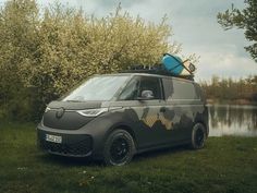 a car with a surfboard on the roof is parked in front of a lake