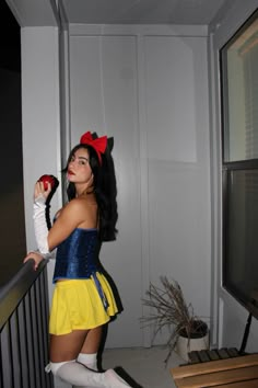 a woman dressed as snow white standing on a balcony