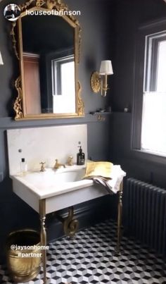 a white sink sitting under a mirror next to a black and white checkered floor