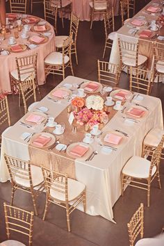 the table is set with pink napkins and place settings for guests to sit at