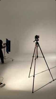 a camera and tripod set up in front of a white background for a photo shoot