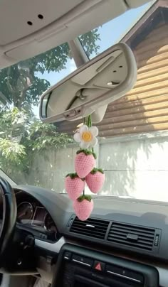 the interior of a car is decorated with fake strawberries and flowers, hanging from the dash board