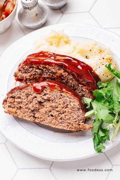 meatloaf and mashed potatoes on a white plate with sauce drizzled over them