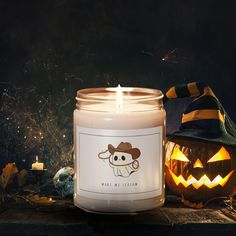 a candle that is sitting next to some pumpkins