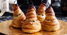 four croissants with googly eyes are on a plate