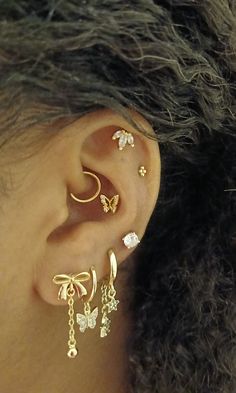 a close up of a person's ear with three different types of earrings on it