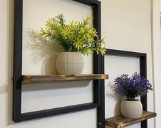 two vases with flowers are sitting on shelves