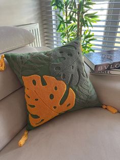 a green and orange pillow sitting on top of a couch