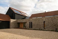 a brick building with a solar panel on the roof and two garages behind it