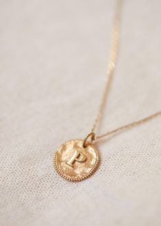 Gold medal 375 thousandths / 9 carats;Letters in relief melted into the hammered medal;Contour of the medal in millegrain;Diameter 1 cm / 0.39 in;Thickness 1.2 mm / 0.05 in;The oval pendant ring allows you to hang several medals on the same chain Gold Locket, Letter P, Letter I, Gold Letters, Oval Pendant, Pendant Rings, Letter Necklace, Parisian Style, Initial Necklace