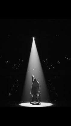 black and white photograph of person on stage with spotlight