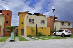 a white car parked in front of two multi - colored houses