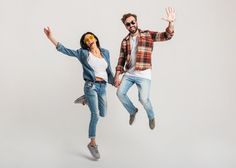 two people are jumping in the air with their arms out and one person is wearing sunglasses