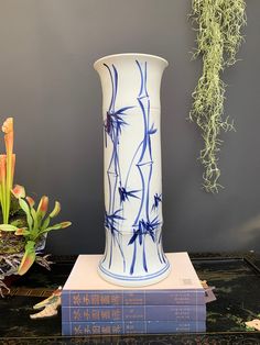 a white and blue vase sitting on top of a table next to two bookends