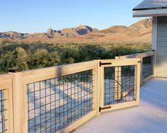 a wooden fence on the side of a building with mountains in the background