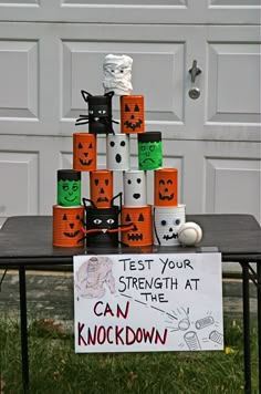 a sign that says test your strength at the can knockdown with pumpkins on it