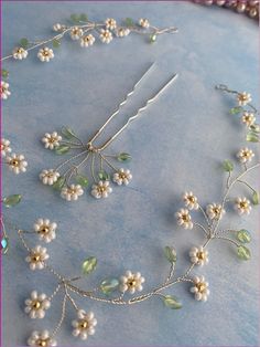 a close up of a necklace with flowers and leaves attached to the neckline on a blue surface