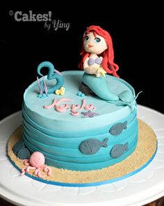 there is a birthday cake that looks like a little mermaid sitting on top of it